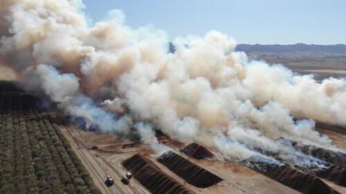 Aerial photo of almond shell piles on fire. 